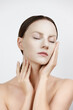 © photoaliona - Face Skin Care moisturizing Korean cosmetics concept. Portrait Of Beautiful woman applying and smoothing White Sheet Mask