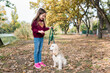 © tgordievskaya - Cute little girl training her dog outside. Child walking with cocker spaniel in the park on warm autumn day. Pets and kids companionship concept