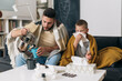 © cherryandbees - father and son catch a cold. they are sitting at home