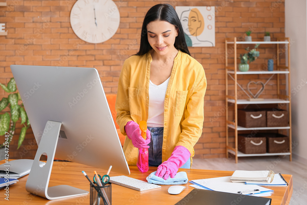Young woman cleaning computer at home