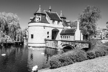 Wall Mural - Ezelpoort (Donkey's gate) medieval entry gate surrounded by lake with white swans part of Brugse Vesten (Bruges' City Ramparts) in Bruges, Belgium