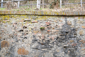 Moldy stone wall through damp walls structure photographed in daylight