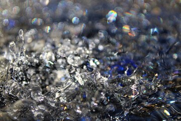 Wallpapers. Frozen movement of water. Drops of water falling and splashing. Sparkles, reflections of light. Blue and violet color.
