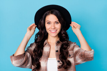 Poster - Photo of young beautiful charming pretty lovely cool smiling positive girl with black hat isolated on blue color background