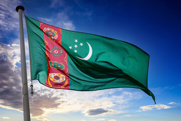 Wall Mural - Turkmenia flag waving against blue cloudy sky