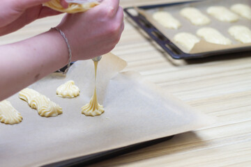 Squeeze the dough out of the pastry bag onto a baking tray for baking eclairs