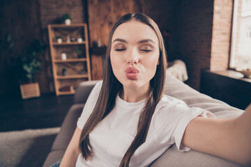 Sticker - Photo of shiny flirty young lady wear white t-shirt sitting sofa recording video sending kiss indoors house room