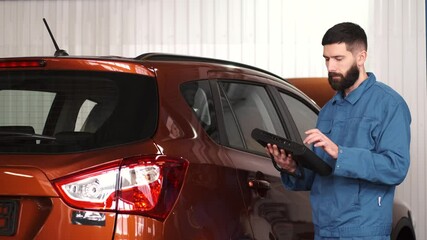 Canvas Print - Mechanic uses a tablet at the car service