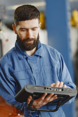 Canvas Print -  ar mechanic with a tablet near car in work clothes