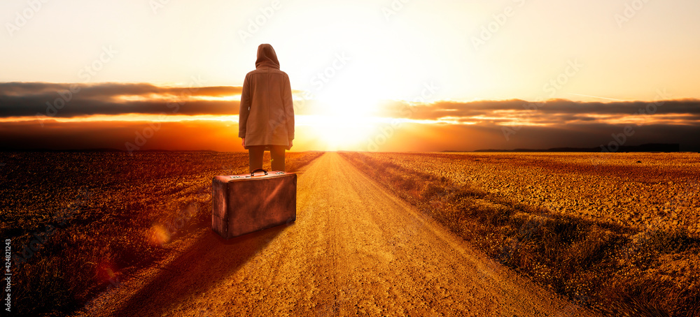 Junge Frau mit einem Koffer bei Sonnenuntergang - obrazy, fototapety, plakaty 