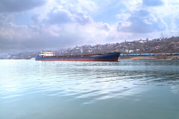 transportation of grain by river transport on a dry cargo ship and delivery to the destination against the backdrop of a beautiful sky