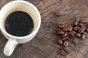 caffee cup and coffee beans on a rustic wooden background