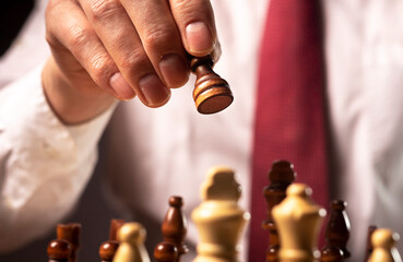 Wall Mural - Business financial strategy concept. Businessman making decision and moving chess piece over other chess figures