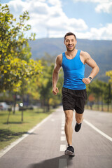 Wall Mural - Man jogging and smiling in the city