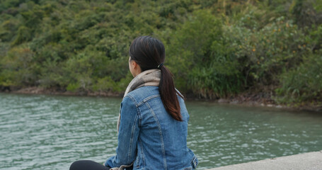 Wall Mural - Woman sit on the pier dock and look around