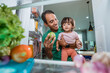 © Odua Images - adorable asian little girl and her dad looking inside the fridge taken from inside
