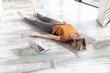 © junky_jess - Yoga nidra practice online at home. Caucasian adult woman lying on the floor in shavasana indoor, next to her laptop, selective focus.