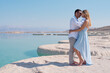 © vera - Romantic couple hug each other on the white beach of dead sea. Marriage in blue sea on paradise without borders. Love story woman and man in summer. vacation and travel in Israel