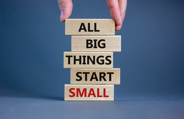 Wall Mural - Business concept growth success process. Wood blocks on grey background, copy space. Businessman hand. Words 'all big things start small'. Conceptual image of motivation.