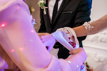 Wall Mural - The hands of the bride and groom are tied with an embroidered towel. Ukrainian wedding traditions