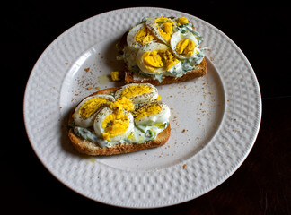 two eggs toast with greek yogurt on it 