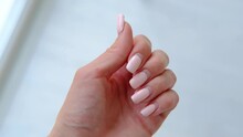 Female Hands With Old Worn Long Lasting Painted Nails With Pastel Pink Gel Polish Cover. Overgrown Manicure. Time For Correction Gel Polish. Nail Care Concept. Woman Shows Regrowth Of Her Nails.