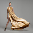 © Alena - Woman in a long gold dress. Fashion