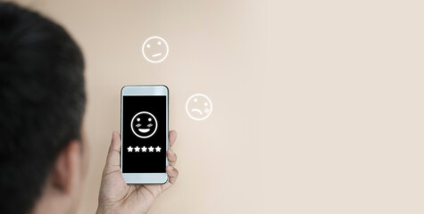 Wall Mural - Hand holding mobile with happy smile face, Customer service evaluation concept, happy Smile face icon to give satisfaction in service. rating very impressed	