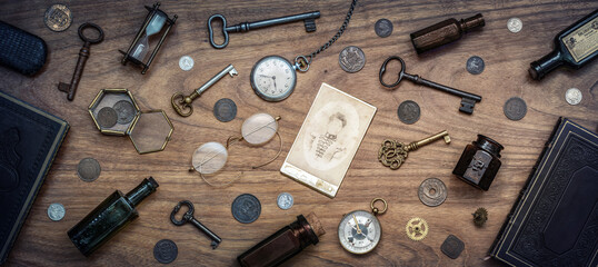 Wall Mural - A collection of antique antiques is spread out on the table. Old coins, glasses, photography, glass bottles, keys, watch and compass. Vintage collection.