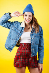 Wall Mural - lifestyle people concept: pretty young school teenage girl having fun happy smiling on yellow background