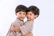 © kanpisut - Twin boys hugging  on white background. Portrait of little son hugging brother or friend. I missing you. Full length happy boy embracing glad brother or friend while standing indoor. Positive meeting
