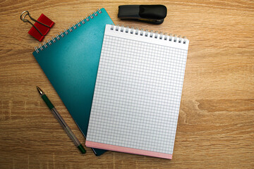 two open notepads a fountain pen a stationery clip and a stapler on the copyspace desk