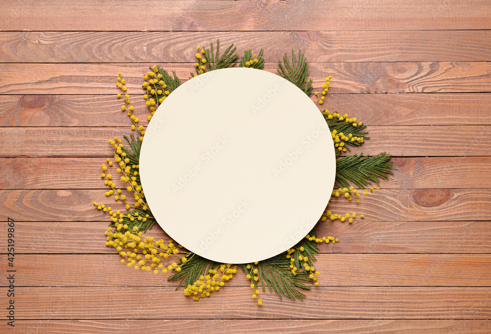 Beautiful mimosa flowers with empty paper sheet on wooden background