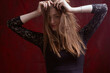 © Roman Kornev - Portrait of a young woman with long brown hair, on a red textured background