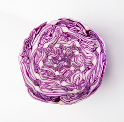 An isolated photo of sliced red cabbage from top. Close up of an intricate pattern of purple color cabbage after slicing it. Fresh vegetable cross section.