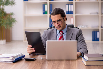 Young male employee sitting at workplace