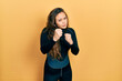 © Krakenimages.com - Young hispanic girl wearing diver neoprene uniform ready to fight with fist defense gesture, angry and upset face, afraid of problem