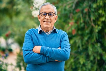 Wall Mural - senior grey-haired man with arms crossed smiling happy standing at the city.