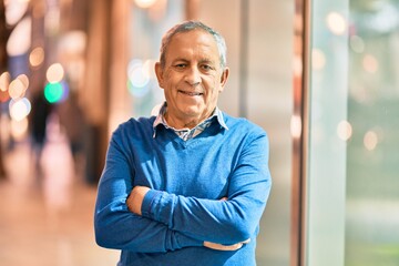 Wall Mural - senior grey-haired man with arms crossed smiling happy standing at the city.