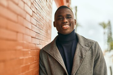 Young african american man smiling happy standing at the city