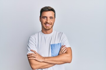 Handsome caucasian man wearing casual clothes happy face smiling with crossed arms looking at the camera. positive person.