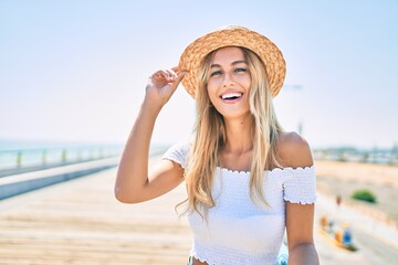 Poster - Young blonde tourist girl smiling happy looking to the camera walking at the promenade.