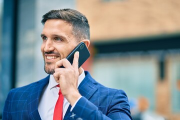 Wall Mural - Young caucasian businessman smiling happy talking on the smartphone at the city.