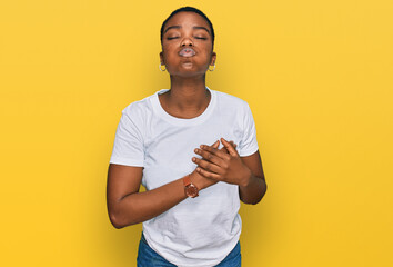 Canvas Print - Young african american woman wearing casual white t shirt puffing cheeks with funny face. mouth inflated with air, crazy expression.