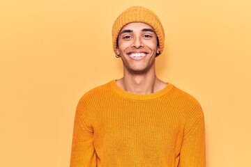 Wall Mural - Young african amercian man wearing wool cap with a happy and cool smile on face. lucky person.