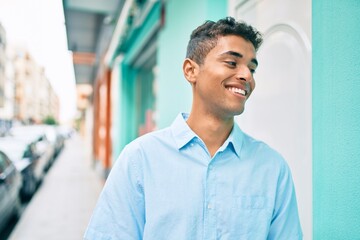 Poster - Young latin man smiling happy walking at the city.