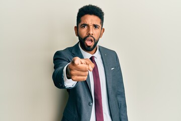 Poster - Handsome hispanic man with beard wearing business suit and tie pointing displeased and frustrated to the camera, angry and furious with you