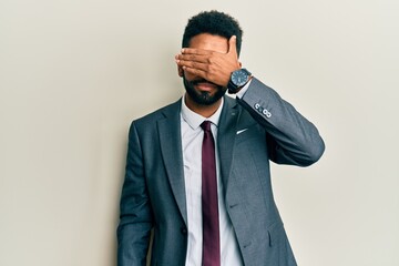 Sticker - Handsome hispanic man with beard wearing business suit and tie covering eyes with hand, looking serious and sad. sightless, hiding and rejection concept