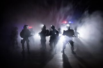 Wall Mural - Anti-riot police give signal to be ready. Government power concept. Police in action. Smoke on a dark background with lights. Blue red flashing sirens. Dictatorship power