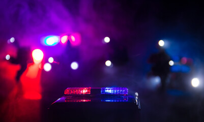 Wall Mural - Police cars at night. Police car chasing a car at night with fog background. 911 Emergency response police car speeding to scene of crime.